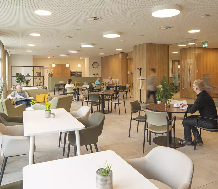 bewoners van WZC Sint-Jozef zitten op stoelen en aan tafels Moments