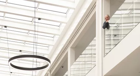 man hangt over leuning te kijken en lachen naar camera